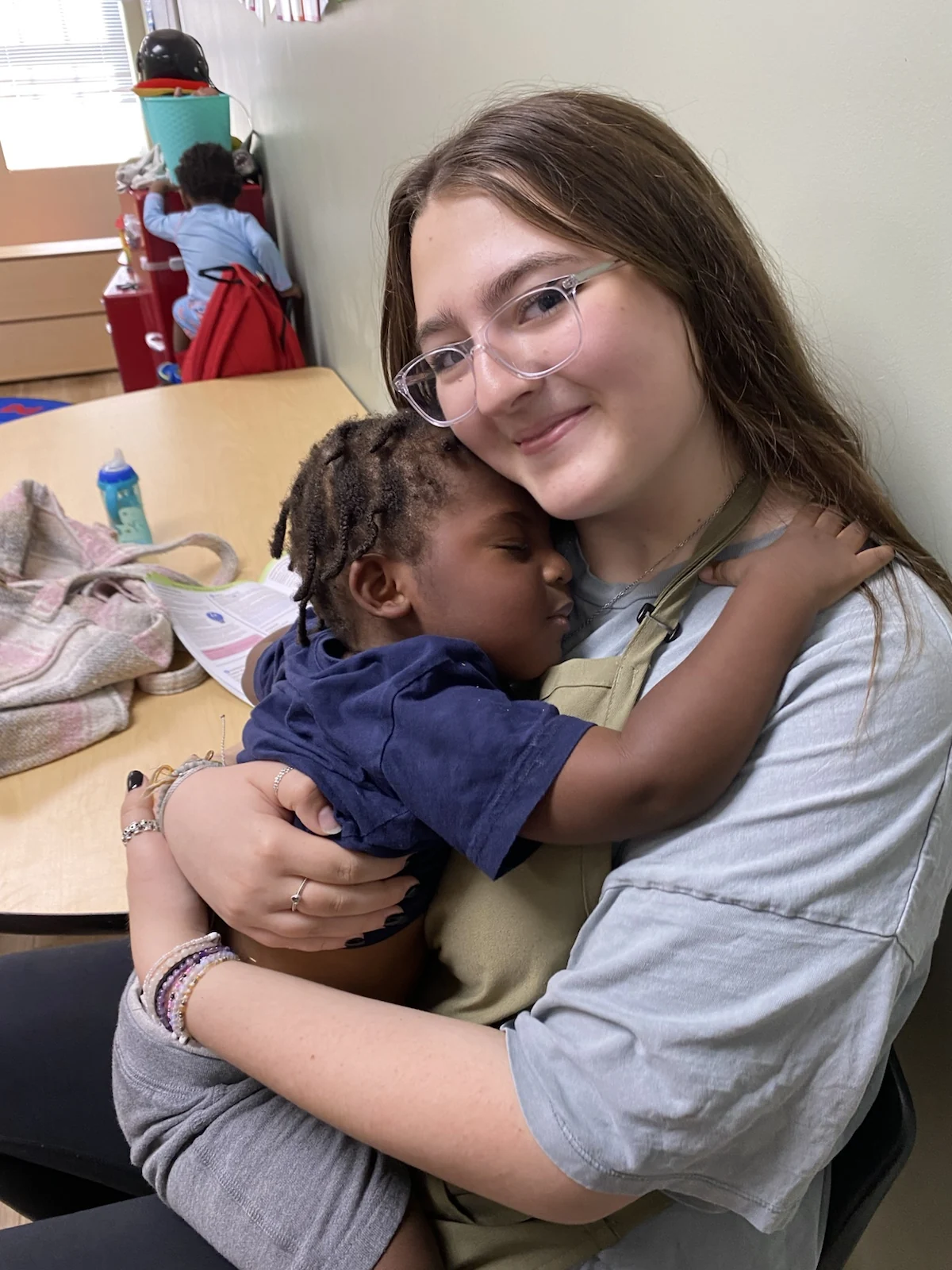 Ms. Dani sharing a quiet classroom moment with a Wild Roots child