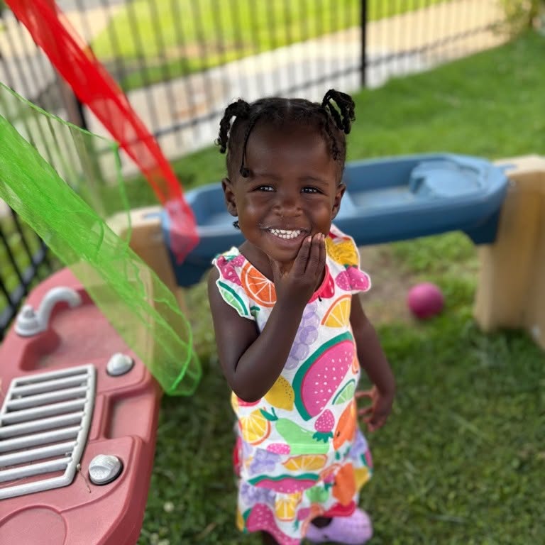 A Wild Roots preschooler smiling during outdoor play