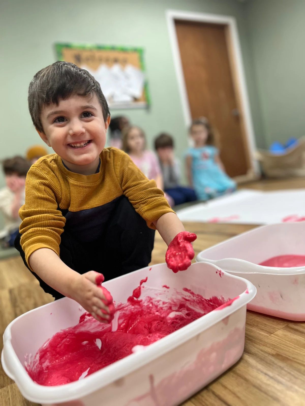 A Wild Roots child joyfully exploring a hands-on sensory activity