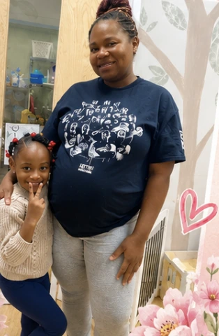 A smiling Wild Roots family member and child together at the center