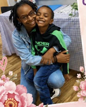 A Wild Roots family member hugging a smiling child